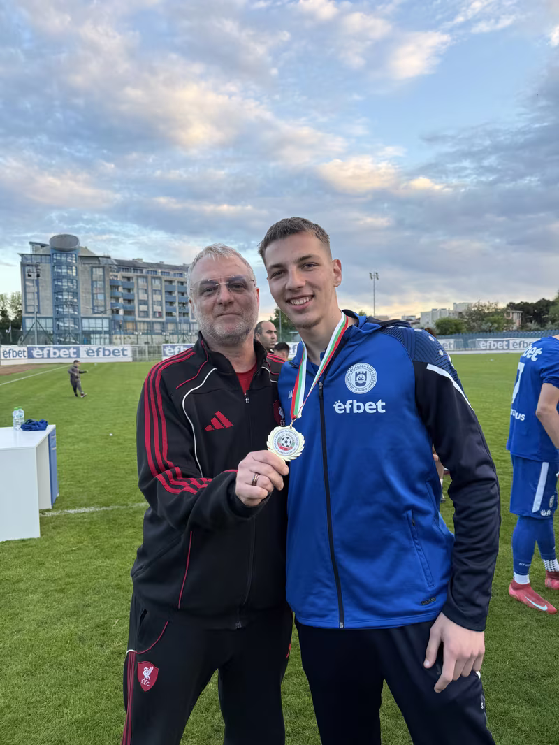 Nikola Nikolov and his father Peter Nikolov celebrating with a medal on the pitch